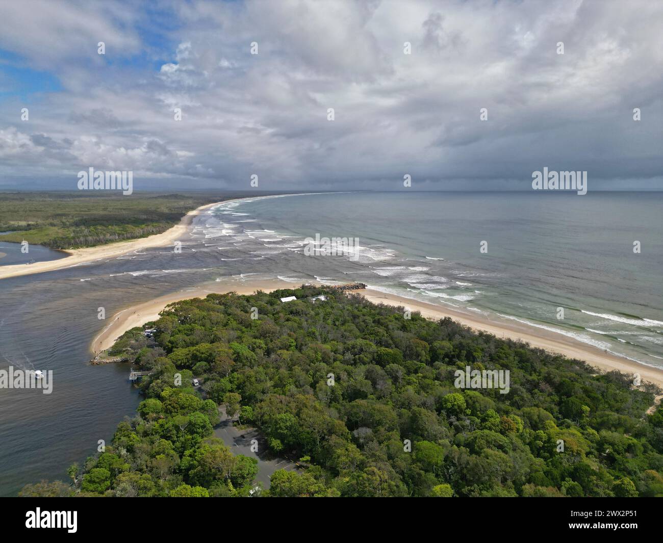 Aerial view of daytime ocean shore with green trees and sand Stock Photo