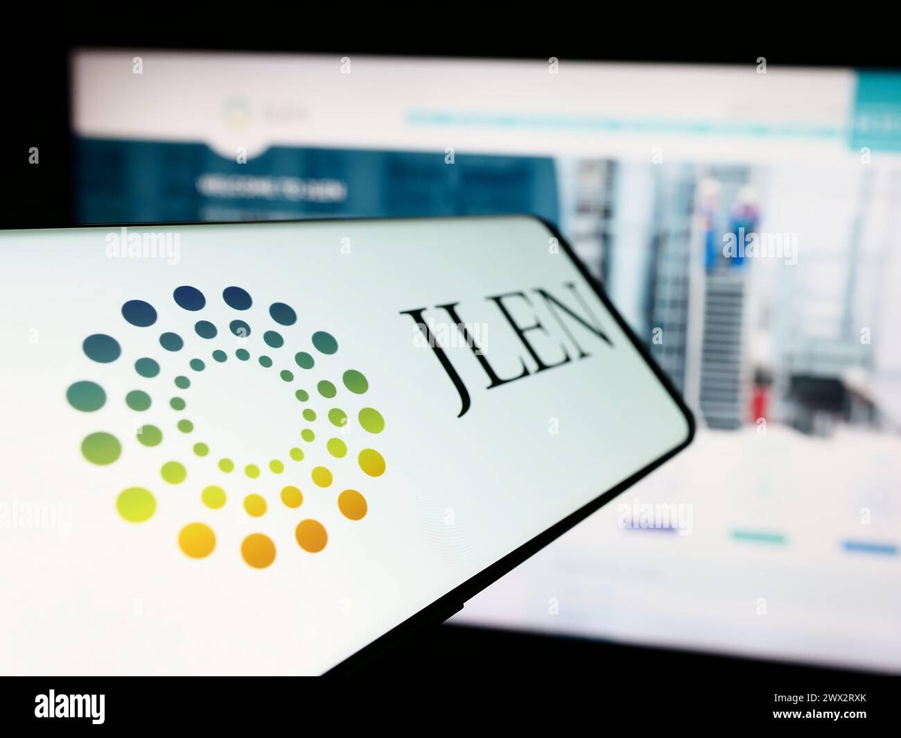 Cellphone with logo of company JLEN Environmental Assets Group Limited in front of business website. Focus on center-left of phone display. Stock Photo