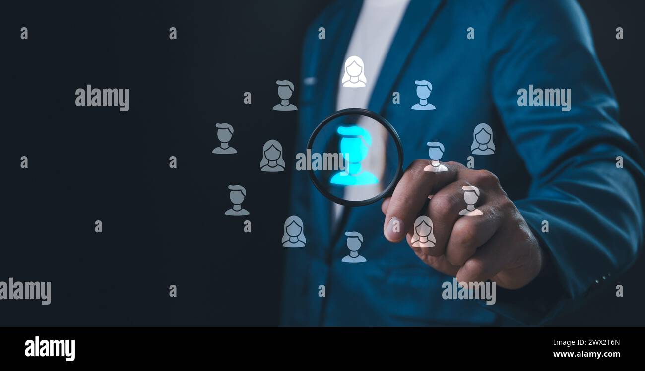 HRM or Human Resource Management, business man use Magnifier glass focus to manager icon which is among staff icons for human development recruitment Stock Photo