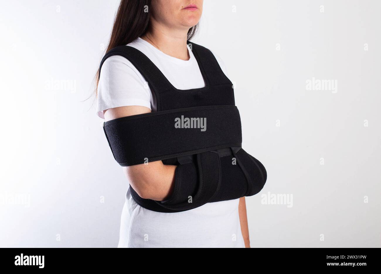 A girl in a medical brace on the shoulder joint for rehabilitation after a collarbone fracture and dislocation. Shoulder sprain. Stock Photo