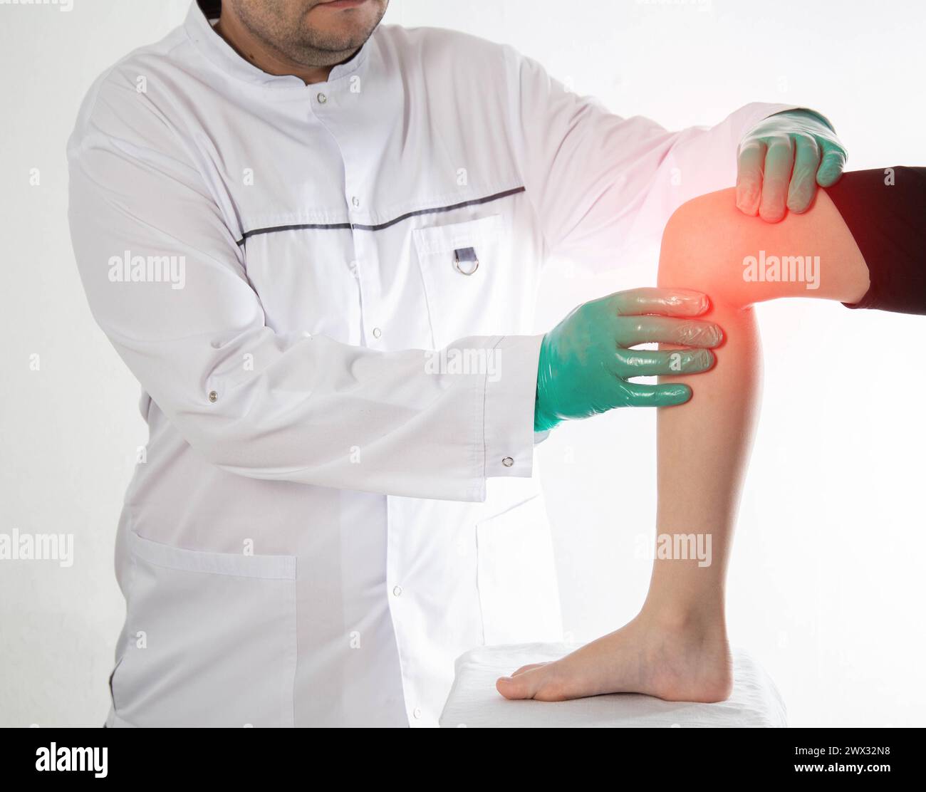 A doctor traumatologist orthopedist examines the knee joint of a child who has knee pain. Concept of growing pains in children. Dislocation and injury Stock Photo