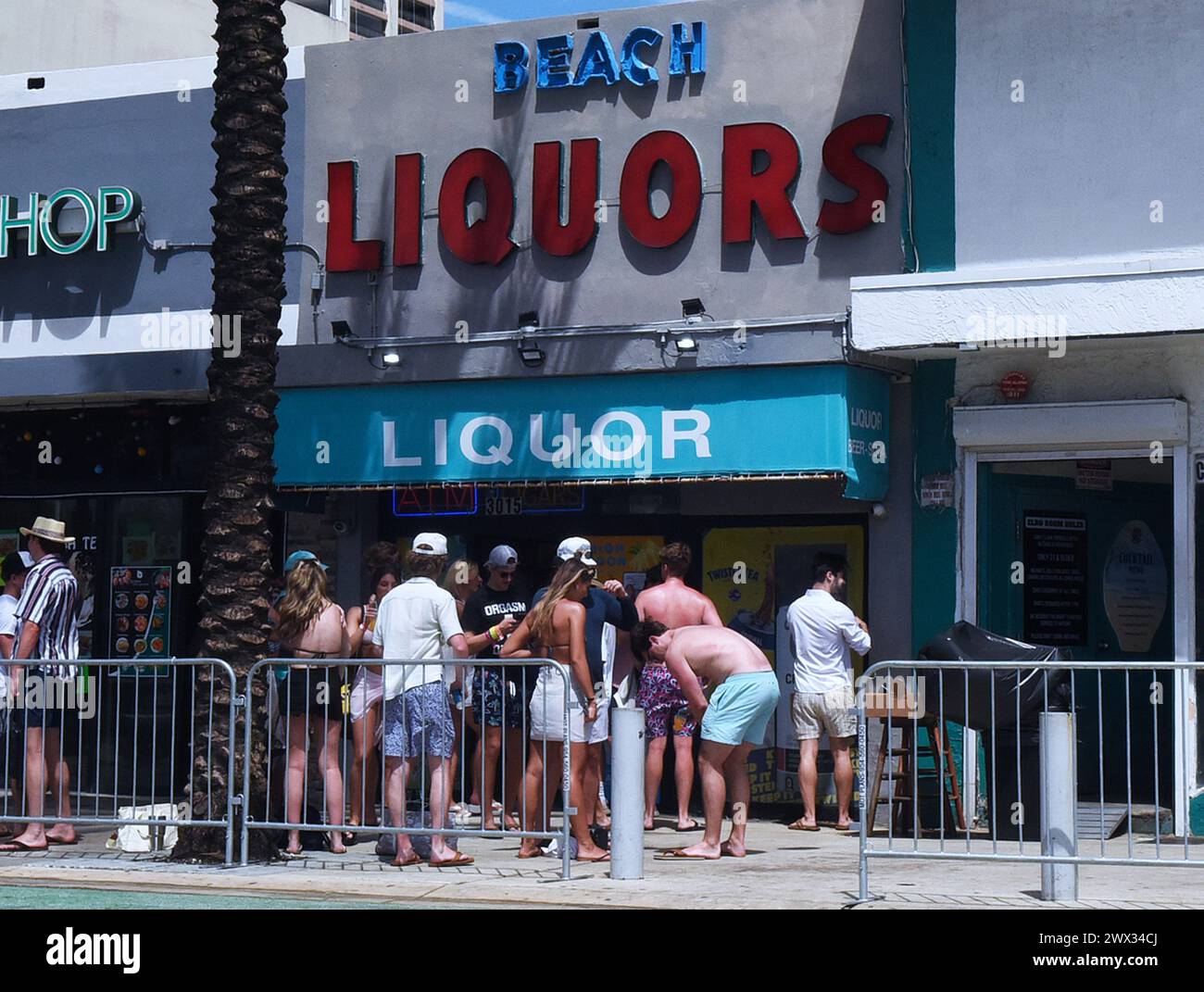 People gather outside a liquor store as college students and others