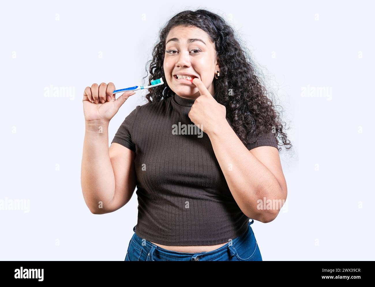Girl suffering from gum pain holding toothbrush. Young woman with