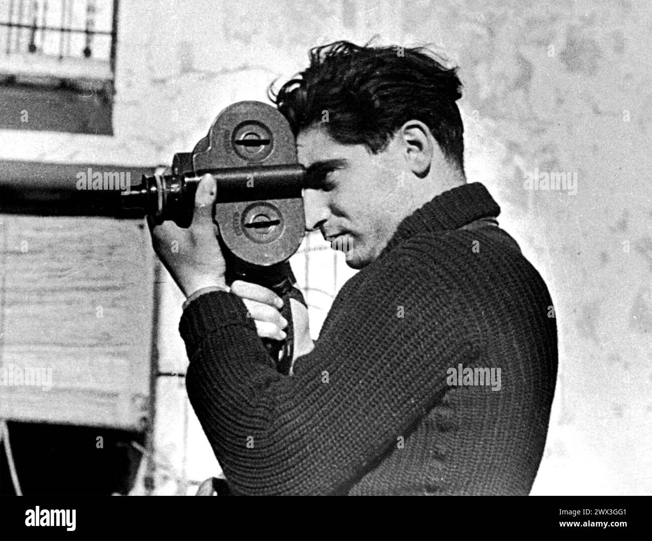 ROBERT CAPA (1913-1954) Hungarian-American war photojournalist using a movie camera during the Spanish Civil War in May 1937. Photo:  Gerda Taro Stock Photo