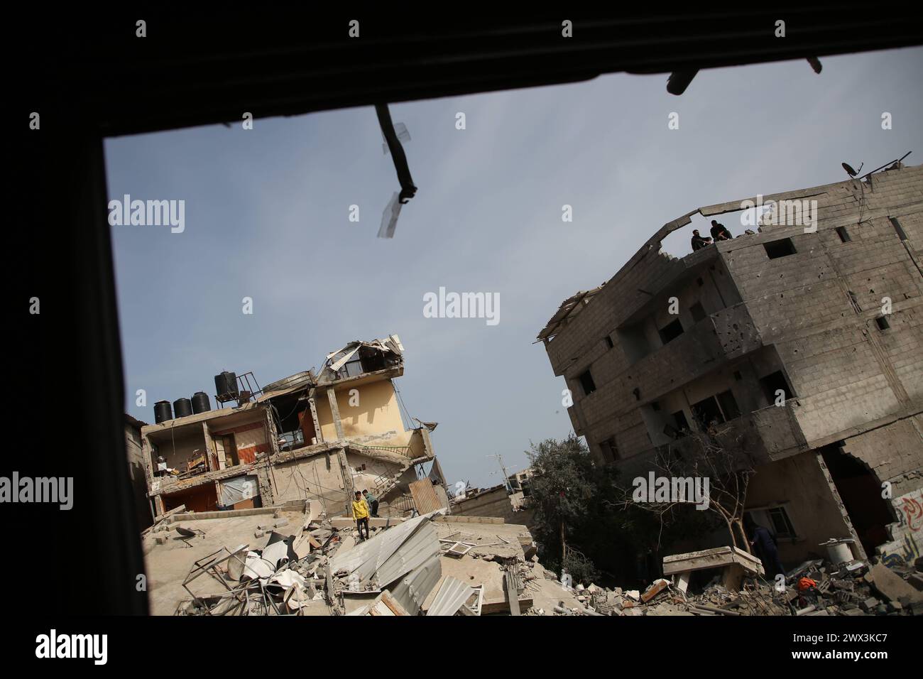 Palestinians gather to inspect damage of the destroyed building ...