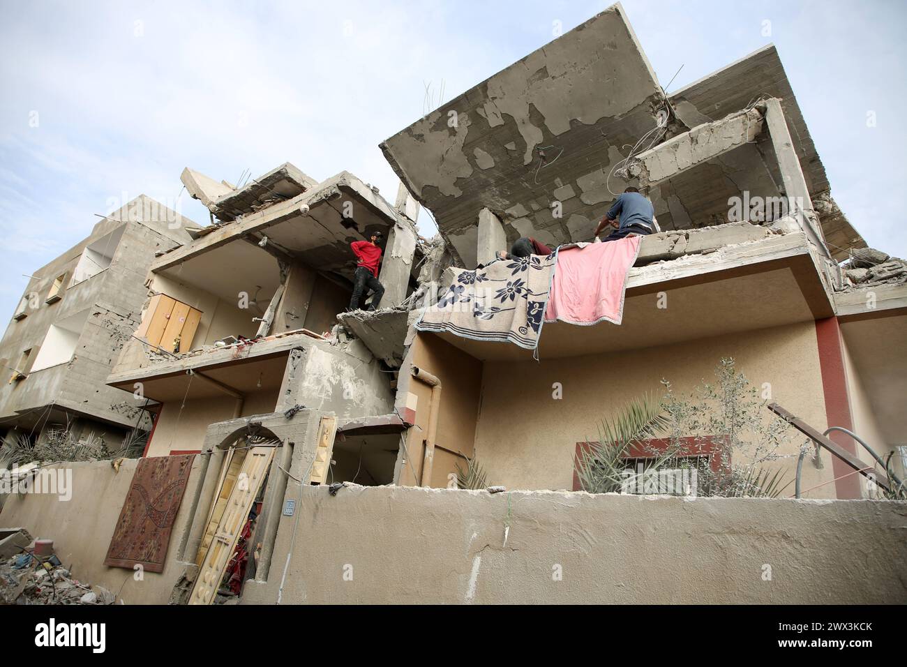 Palestinians gather to inspect damage of the destroyed building ...