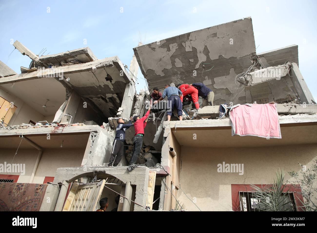 Palestinians gather to inspect damage of the destroyed building ...