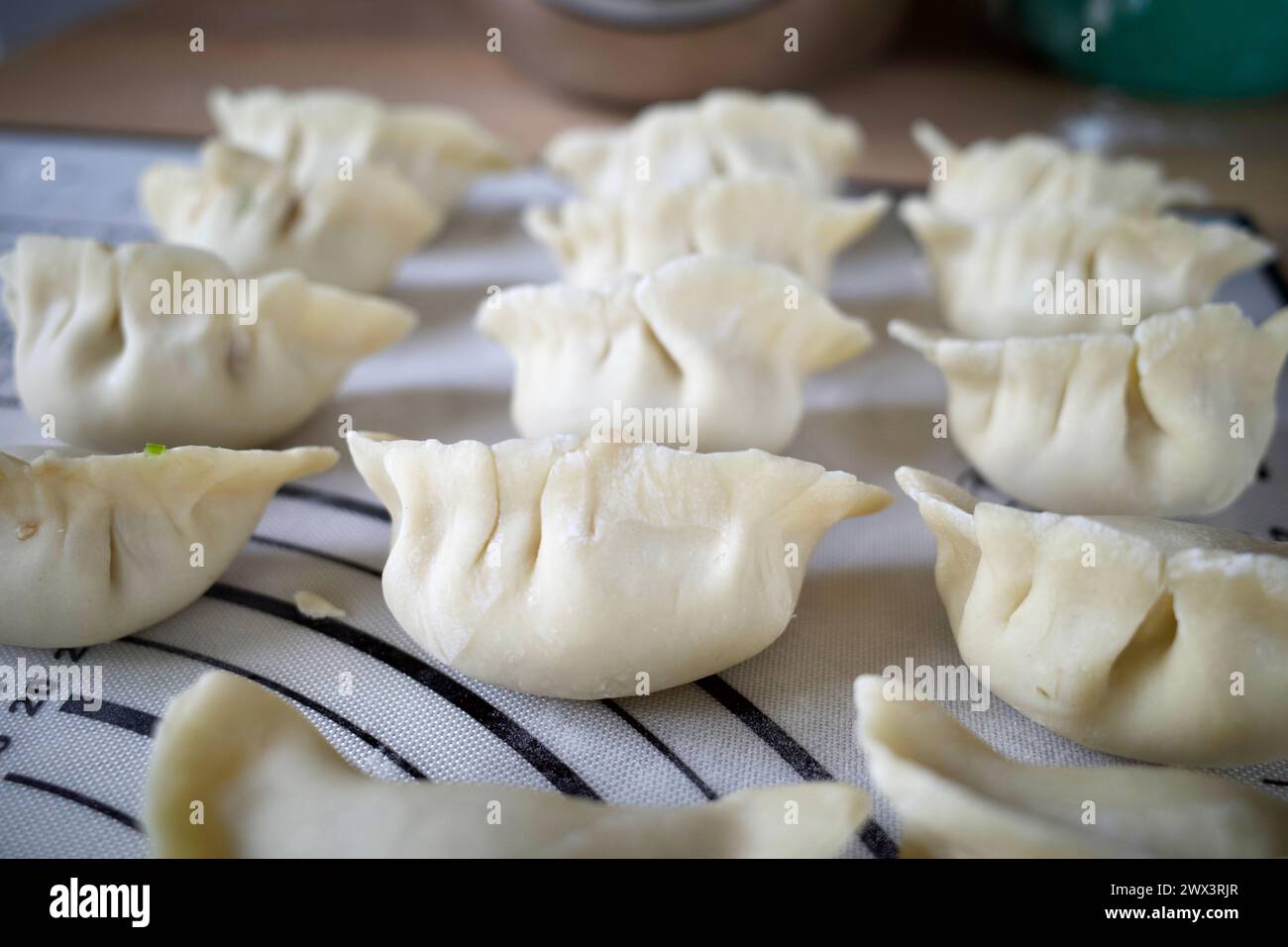 Raw Chinese dumplings on a table Stock Photo