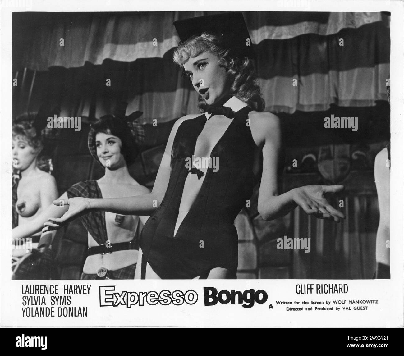 A British Lobby Card of SYLVIA SYMS and dancing girls in a scene from EXPRESSO BONGO 1959 also starring LAURENCE HARVEY, YOLANDE DONLAN and CLIFF RICHARD Produced and Directed by VAL GUEST From the stage play by WOLF MANKOWITZ  and JULIAN MORE Costume Design  BEATRICE DAWSON British Lion Films Stock Photo