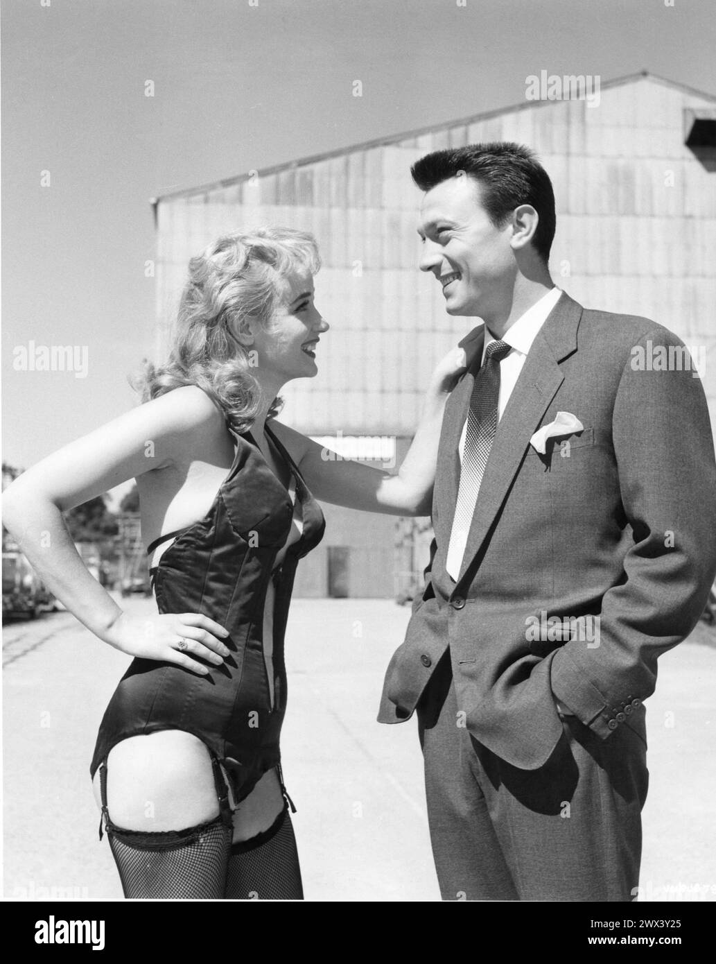 A candid photo of SYLVIA SYMS and LAURENCE HARVEY taken at Shepperton Studios while they were making EXPRESSO BONGO 1959 also starring YOLANDE DONLAN and CLIFF RICHARD Produced and Directed by VAL GUEST From the stage play by WOLF MANKOWITZ  and JULIAN MORE Costume Design  BEATRICE DAWSON British Lion Films Stock Photo