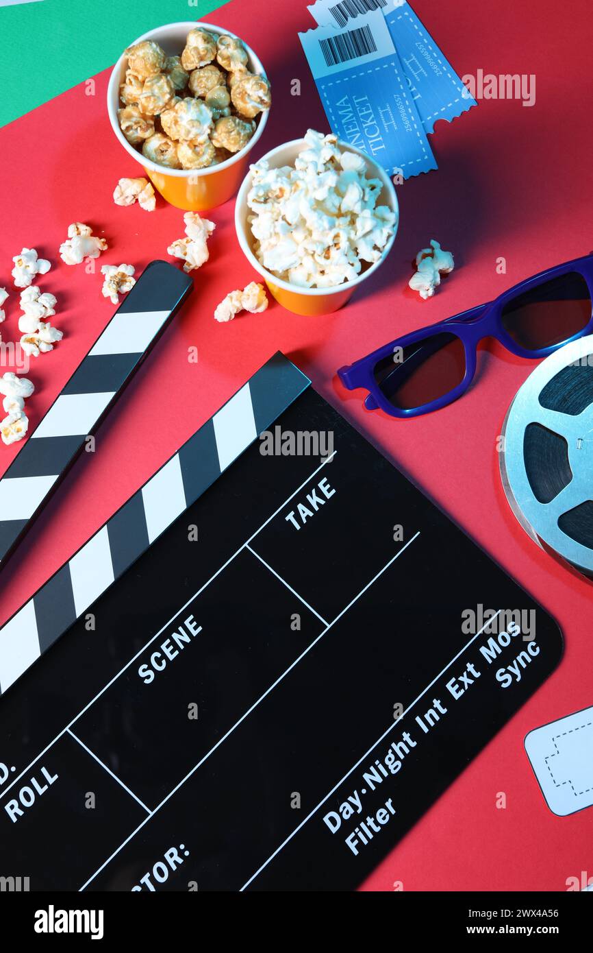Flat lay composition with clapperboard and popcorn on color background Stock Photo
