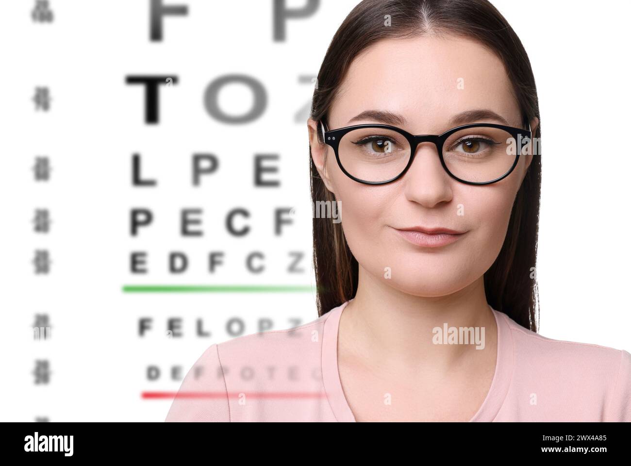 Vision test. Woman in glasses and eye chart on white background Stock