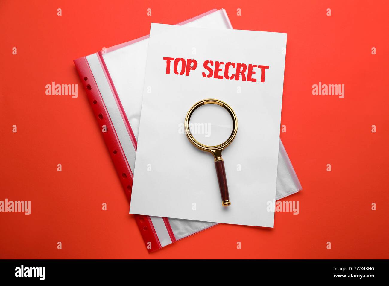 Top Secret stamp. Magnifying glass, sheet of paper and folder on red background, top view Stock Photo