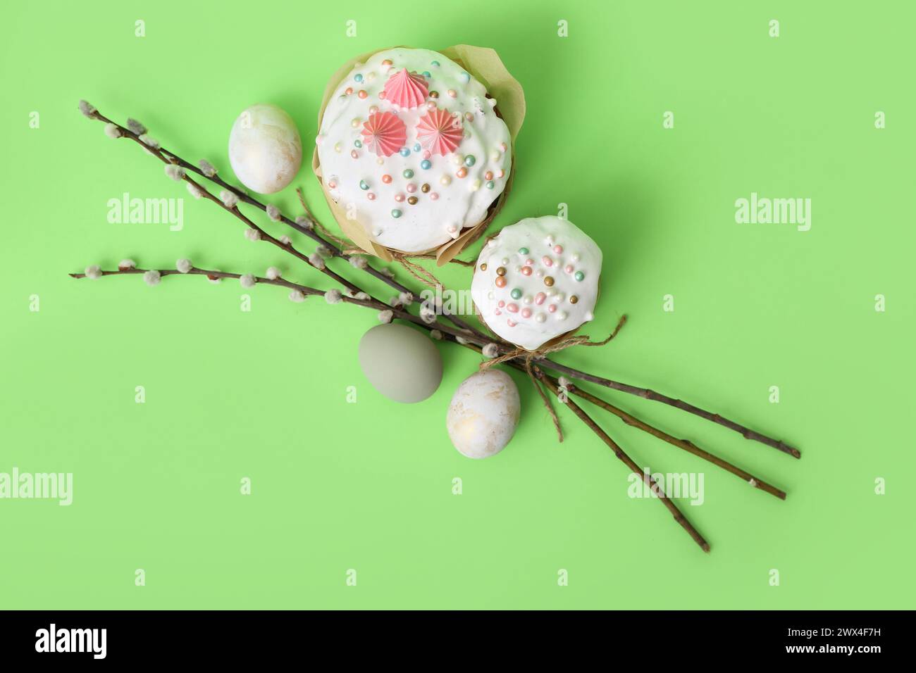 Easter cake, painted eggs and willow branches on green background Stock Photo