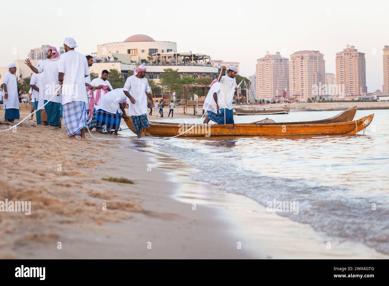 Arabic fishermen on an ancient wooden boat go fishing at sunset. Preservation of national traditions, ancient crafts, historical lifestyle Stock Photo
