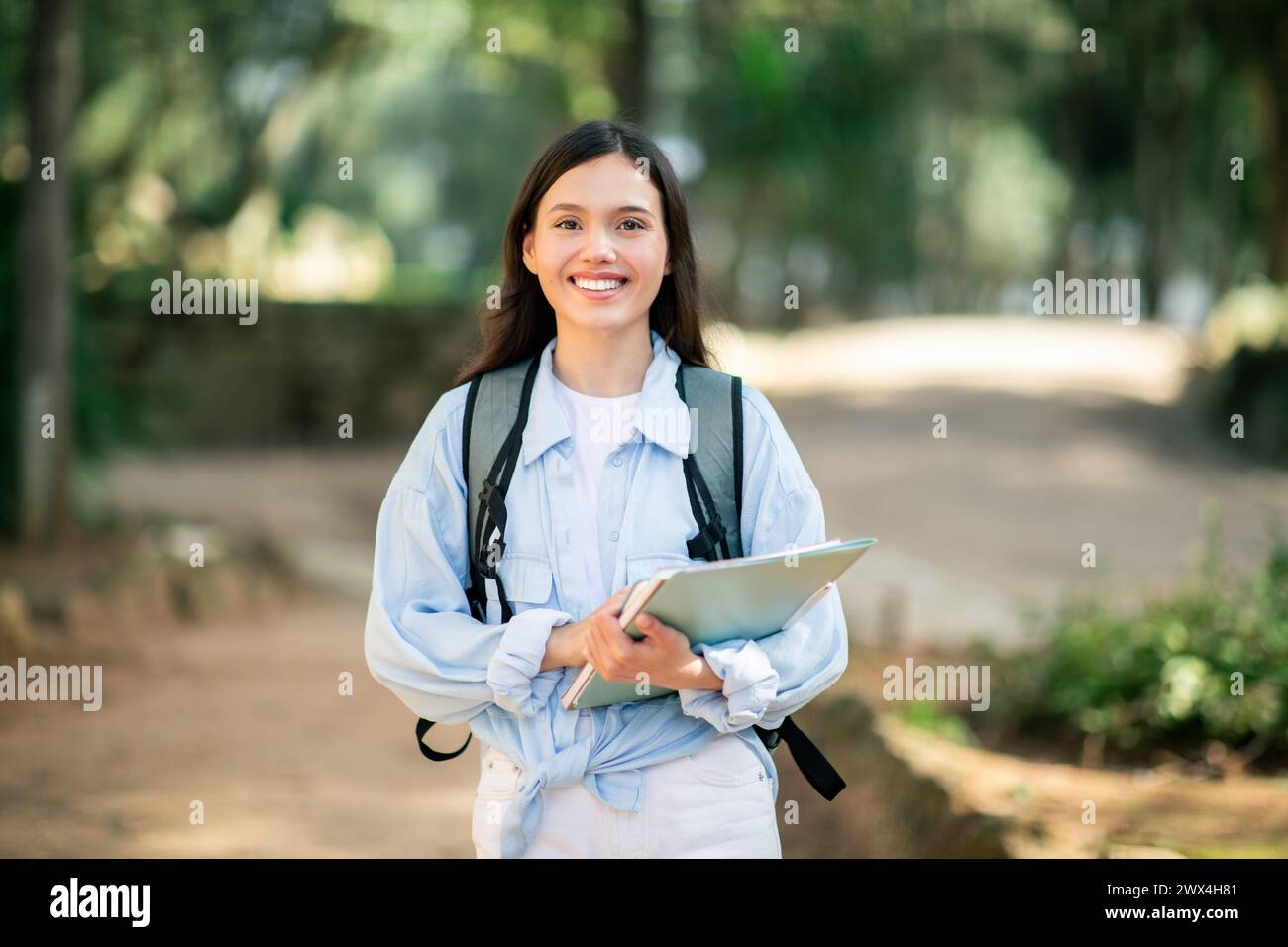 Content young female student with a radiant smile, dressed in white Stock Photo