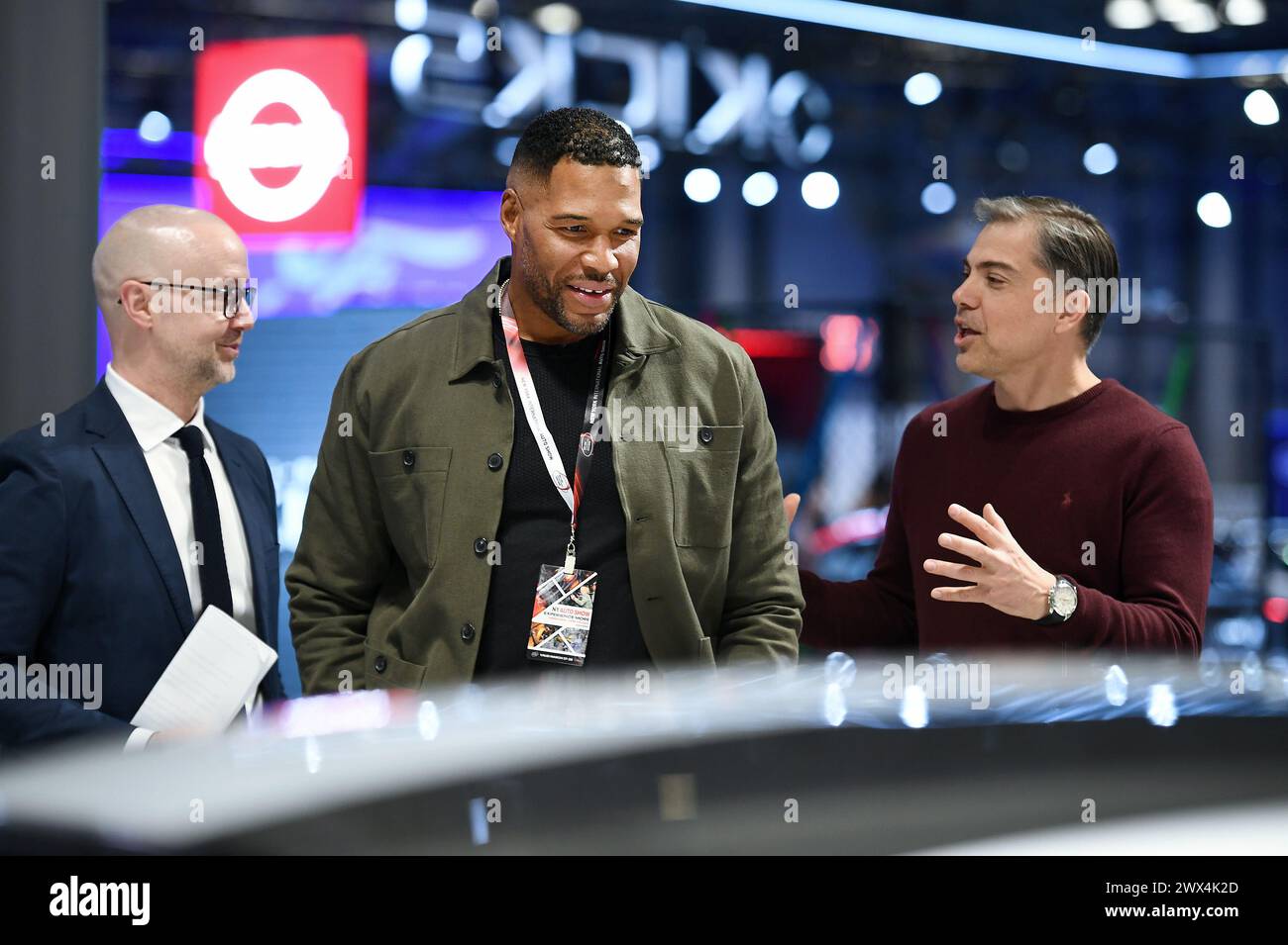TV personality Michael Strahan (c) speaks with Tedson Motors CEO Goran
