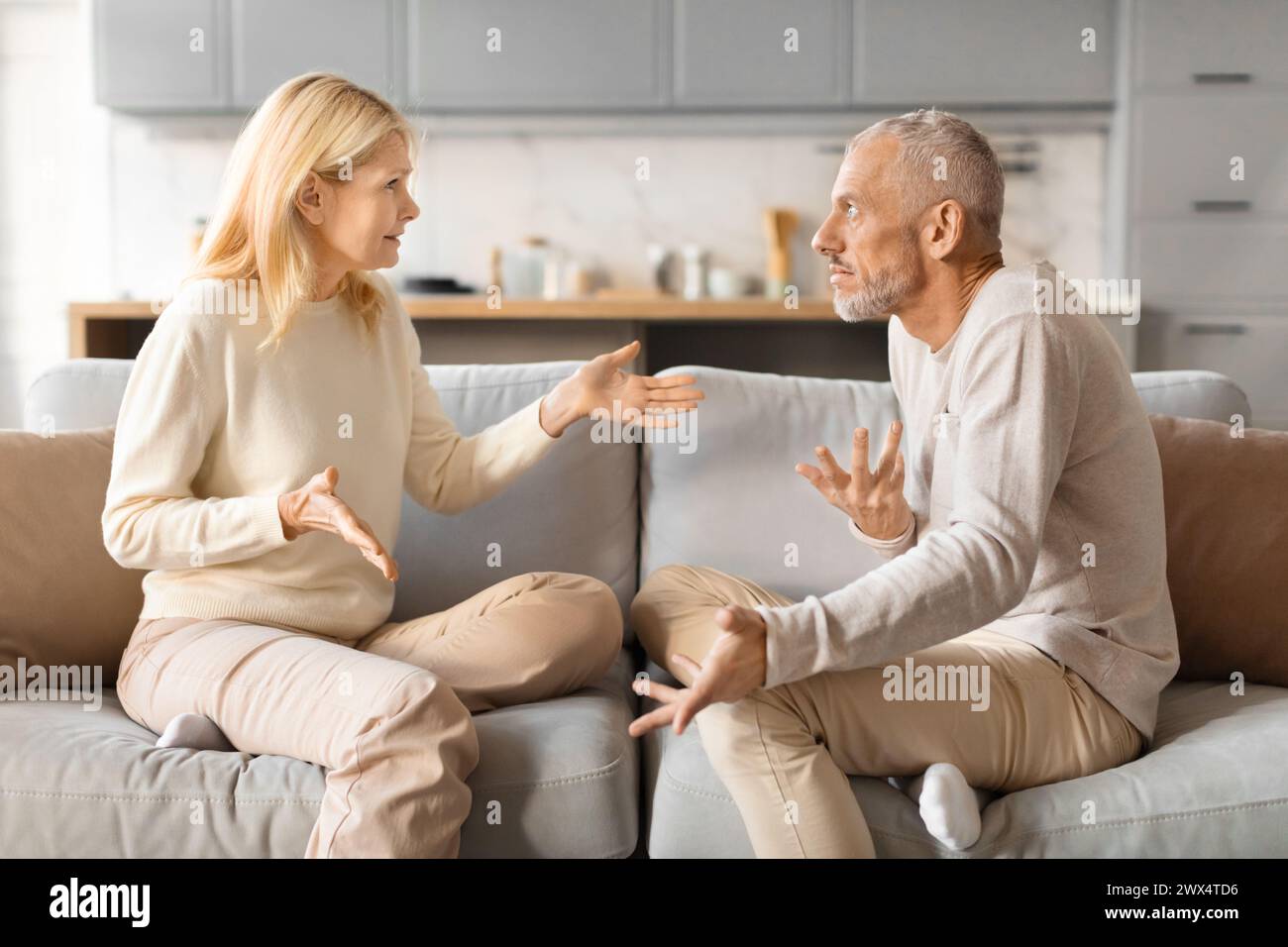 Mature couple engaged in a conversation on the couch Stock Photo