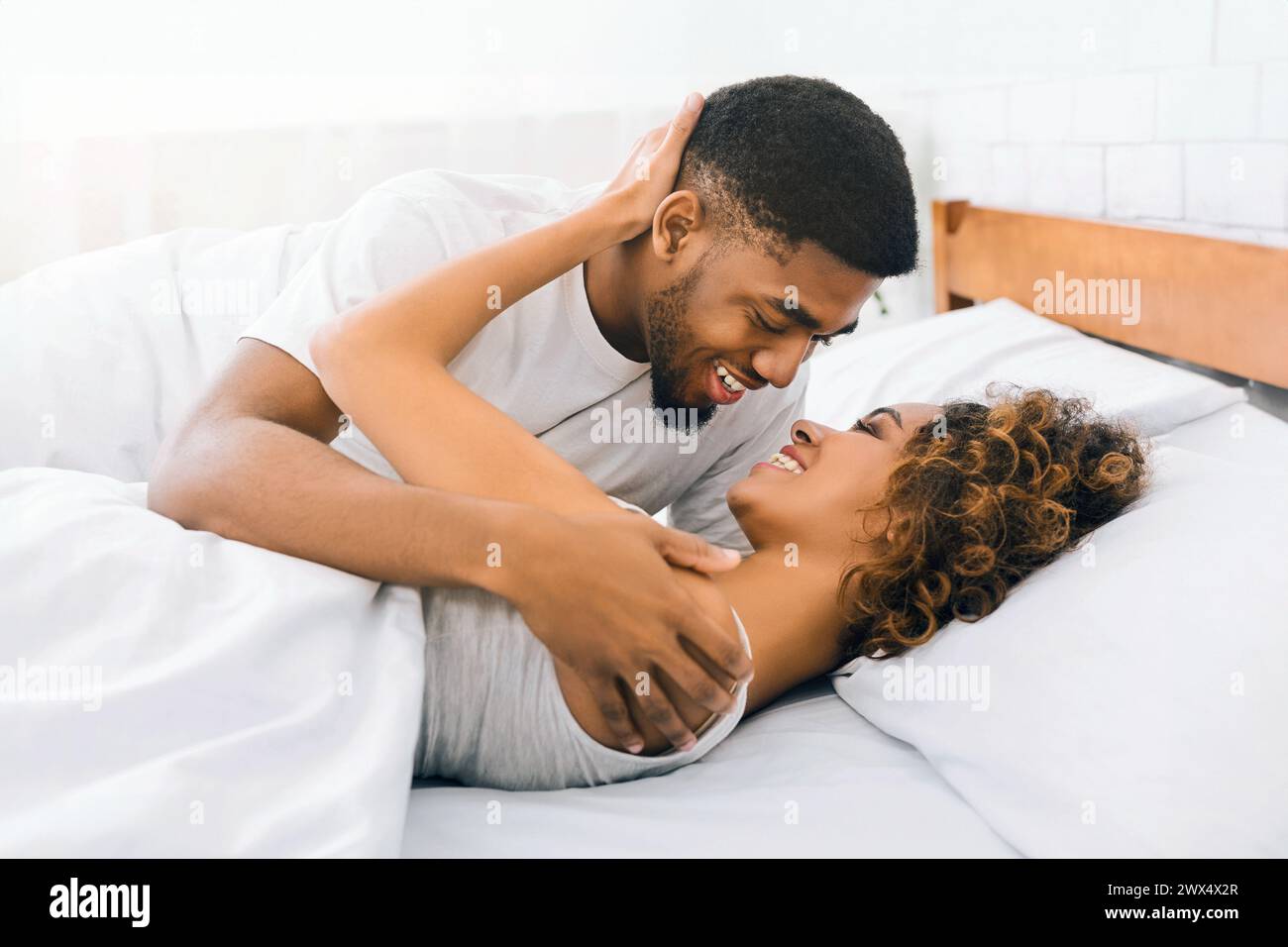 Loving black couple relaxing on bed at home Stock Photo - Alamy