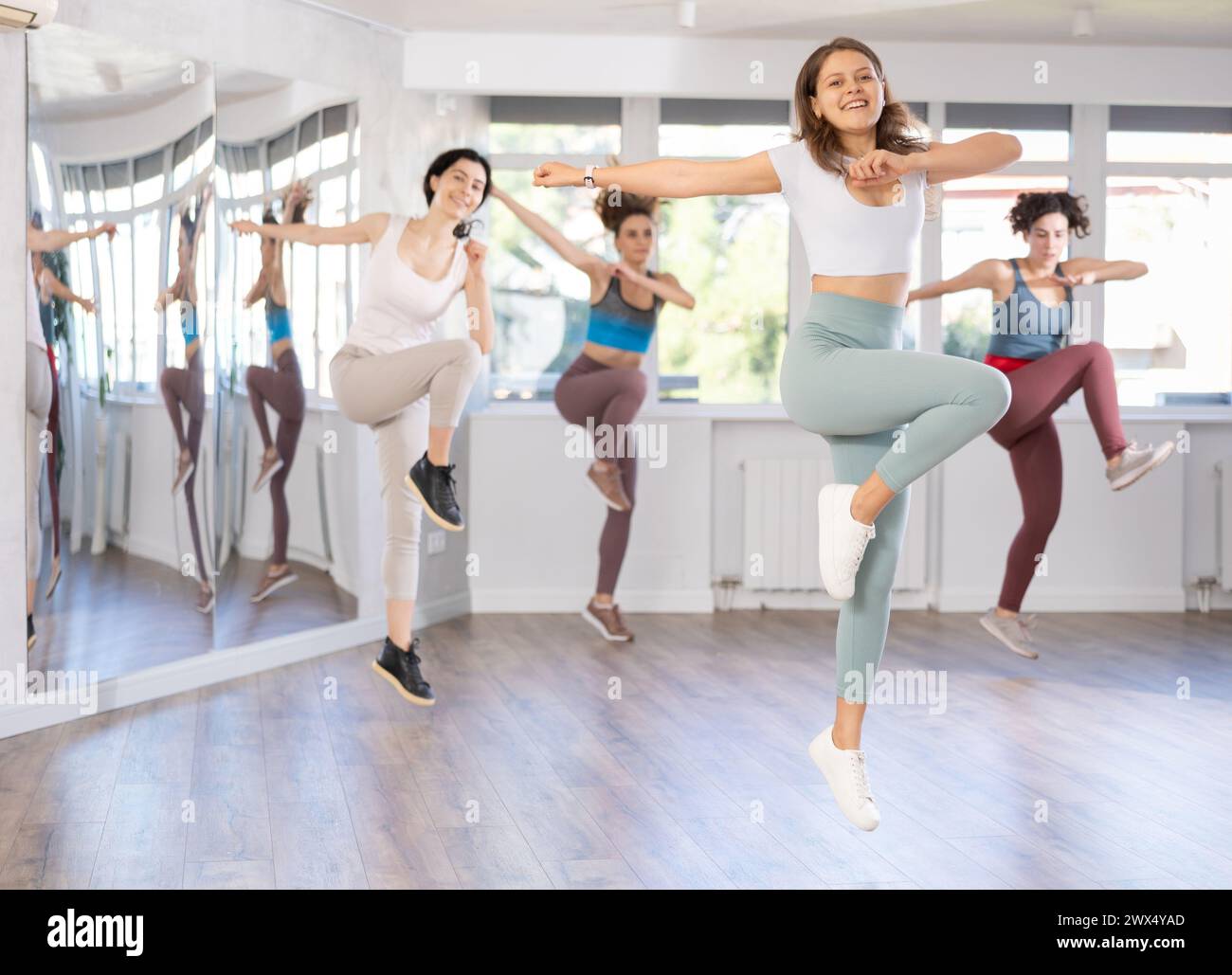 Cheerful girl captured jumping during lively dance fitness routine Stock Photo
