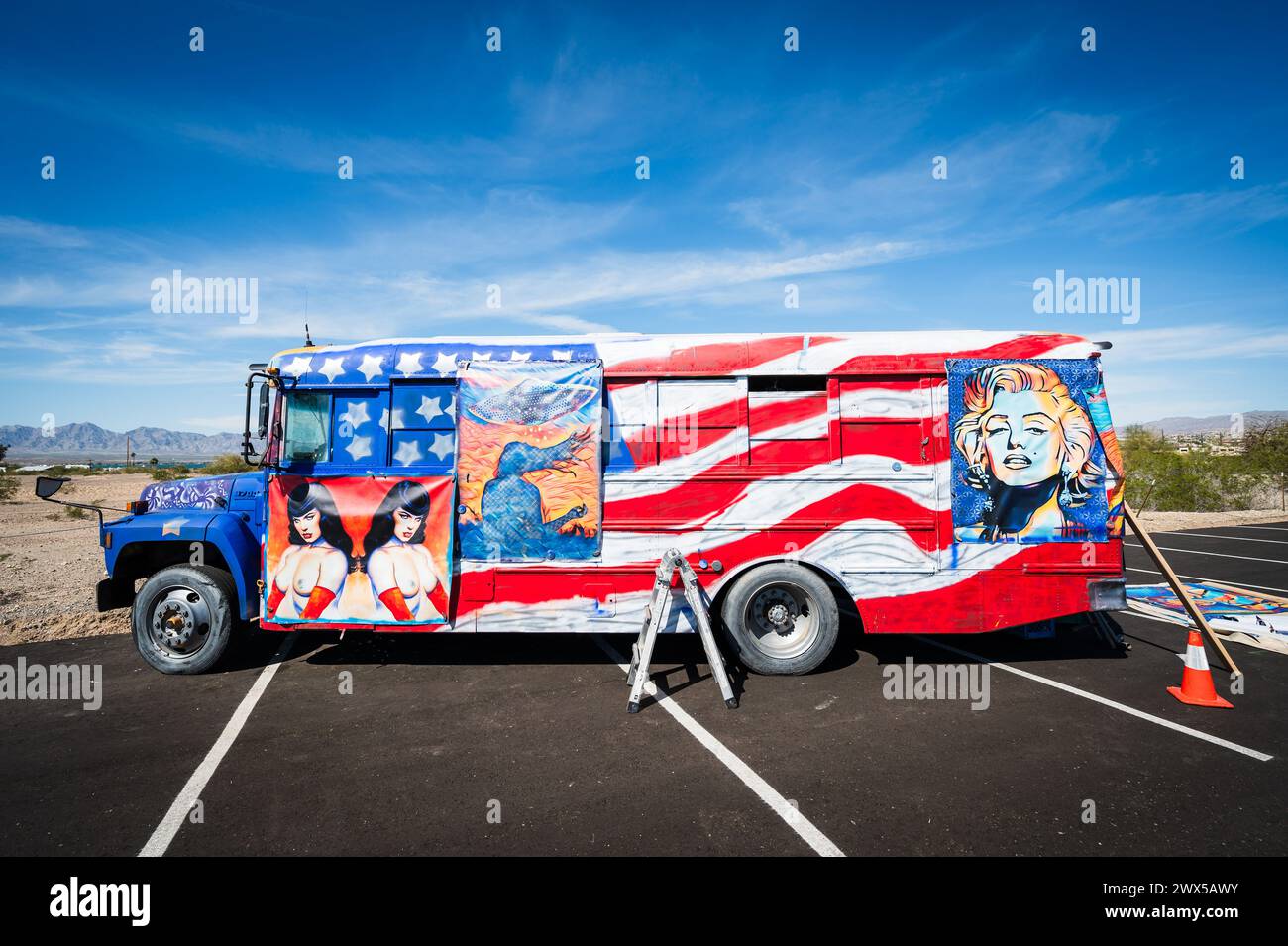 A artist hangs paintings on a custom American flag painted bus. Lake ...