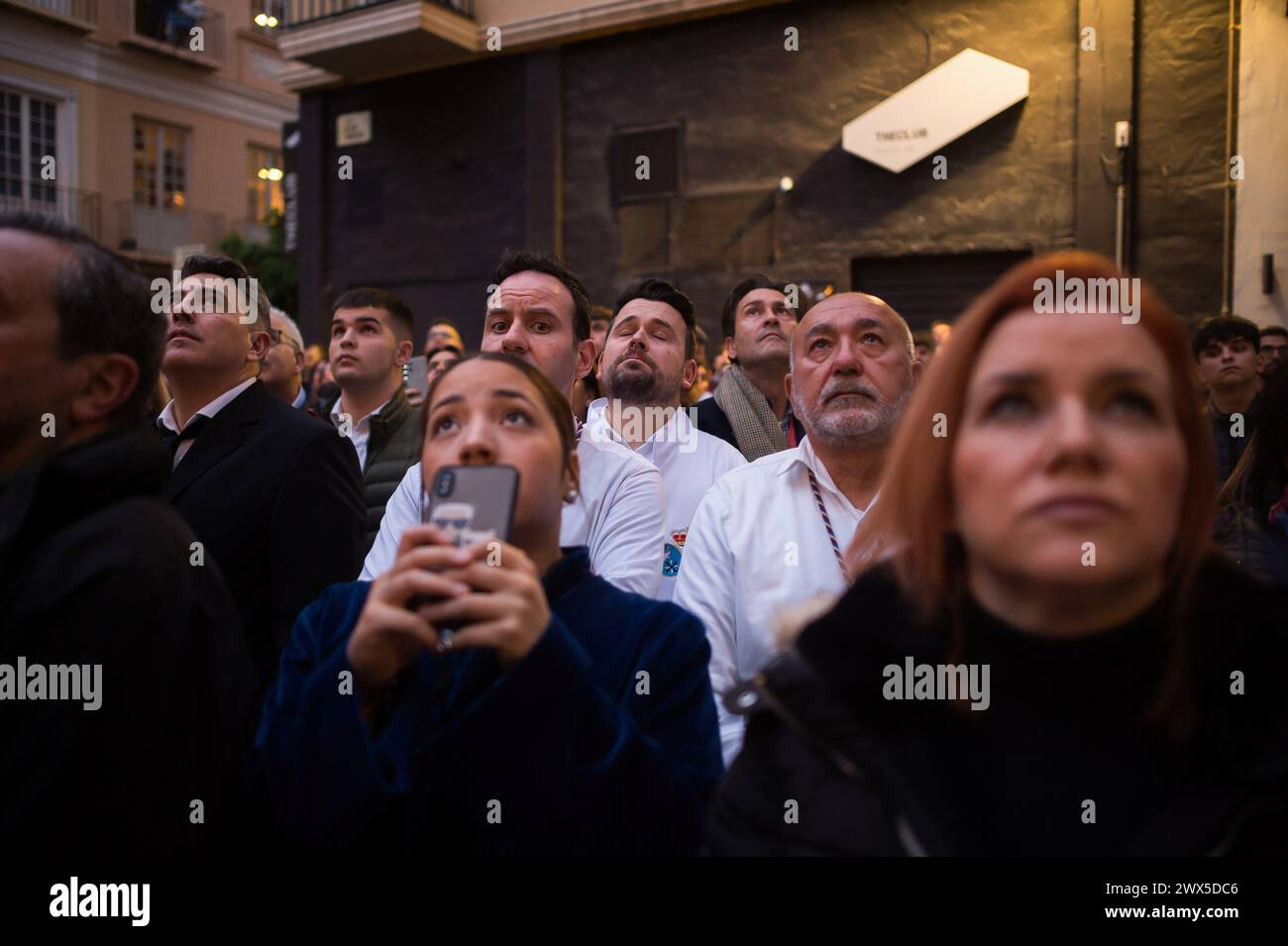 Penitents from the 'Paloma' Brotherhood are seen listening to a member ...