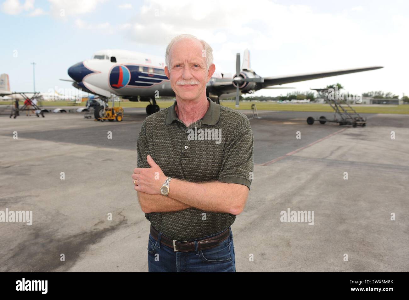 MIAMI, FL - NOVEMBER 17: Captain 'Sully' Sullenberger and Co-pilot Jeff Skiles pose with the Historical 1958 DC7 for a benefit hosted by Historical Flight Foundation. Chesley Burnett 'Sully' Sullenberger, III (born January 23, 1951) is a retired airline captain and aviation safety consultant. He was hailed as a national hero in the United States when he successfully executed an emergency water landing of US Airways Flight 1549 in the Hudson River off Manhattan, New York City, after the aircraft was disabled by striking a flock of Canada geese during its initial climb out of LaGuardia Airport o Stock Photo