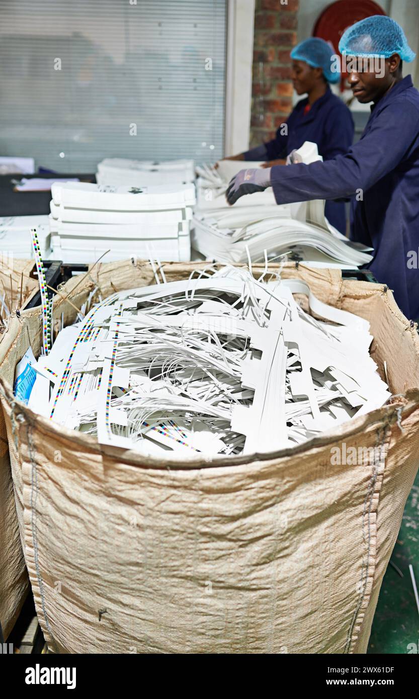 Workers, shredding and printing with paper, bag and documents for distribution, media and press. Employees, factory and publishing, industry and Stock Photo