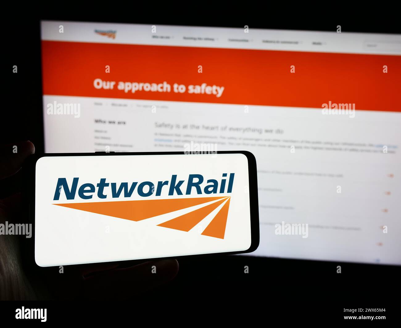 Person holding smartphone with logo of railway infrastructure company Network Rail Limited in front of website. Focus on phone display. Stock Photo