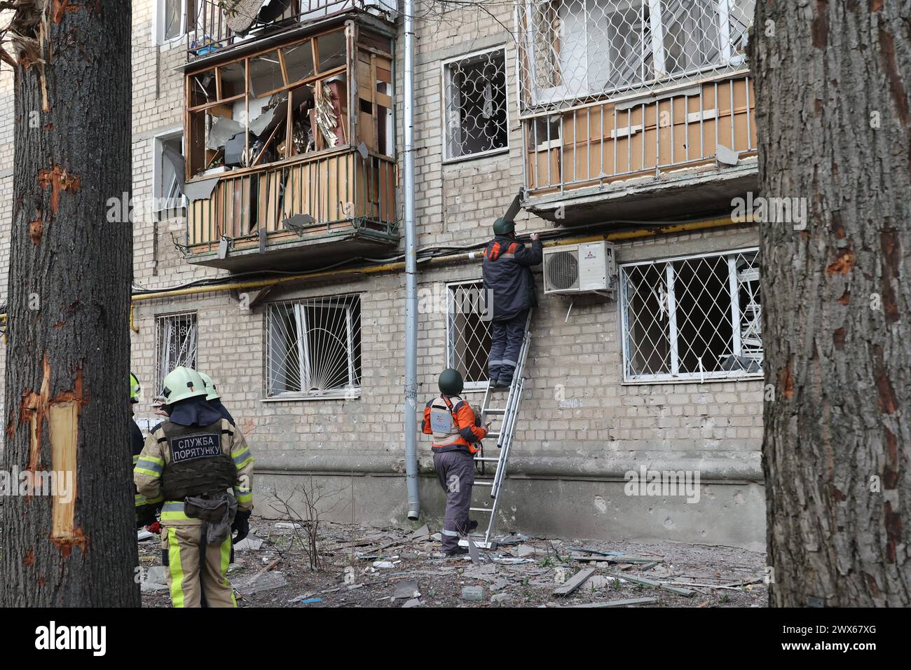 KHARKIV, UKRAINE - MARCH 27, 2024 - Elimination of consequences of a Russian attack with a modernized UMPB D-30 guided bomb in Shevchenkivskyi district of Kharkiv, north-eastern Ukraine. Stock Photo