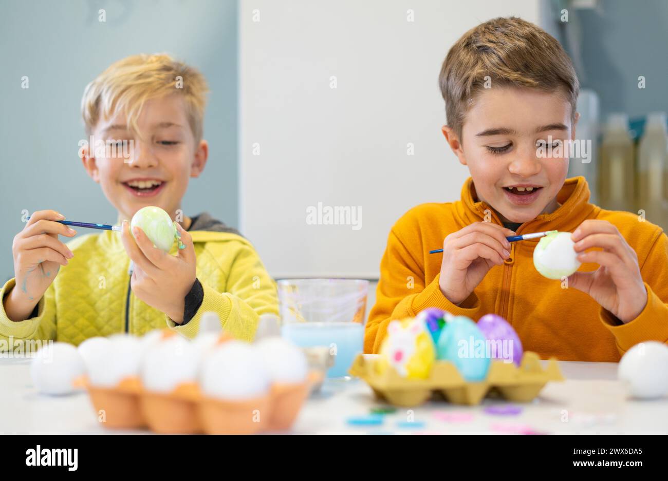 Children having fun painting eggs for Easter Stock Photo