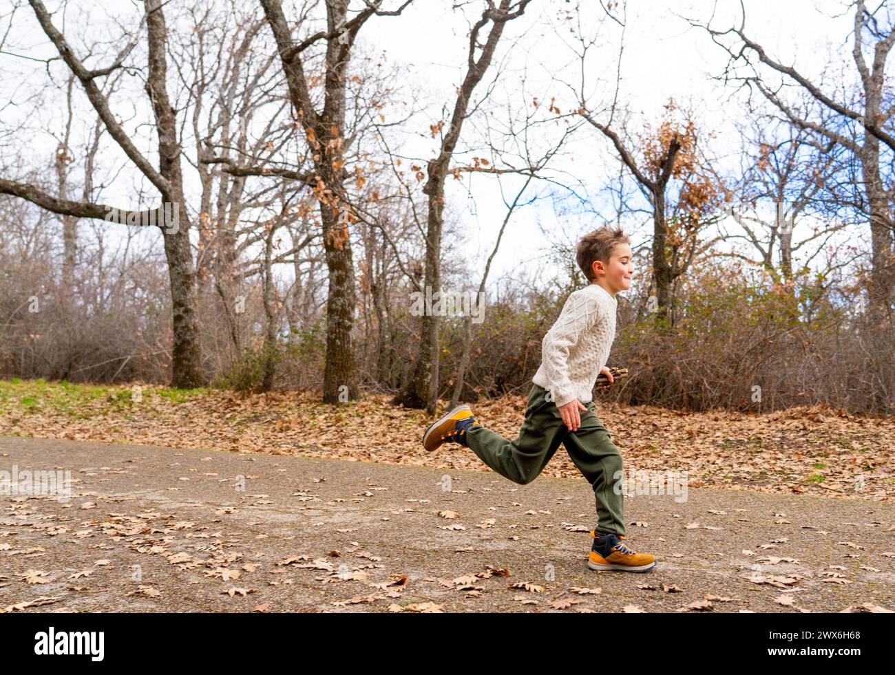 Boy running in nature in an autumn winter landscape Stock Photo - Alamy