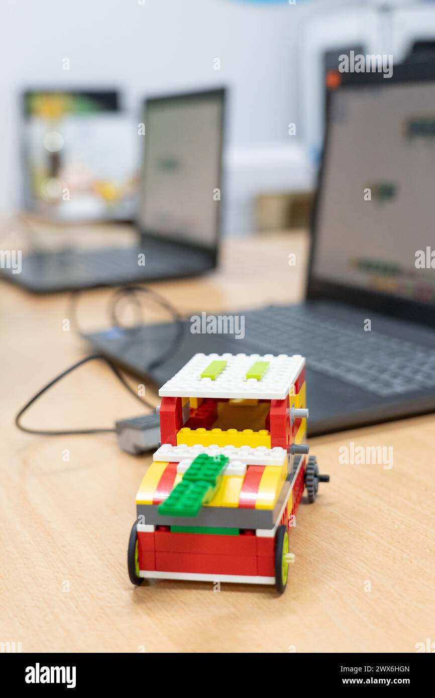 Robot built in a children's robotics workshop with computers in the background Stock Photo