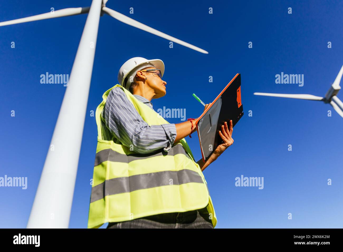 Female engineer working on windmill farm report. Stock Photo