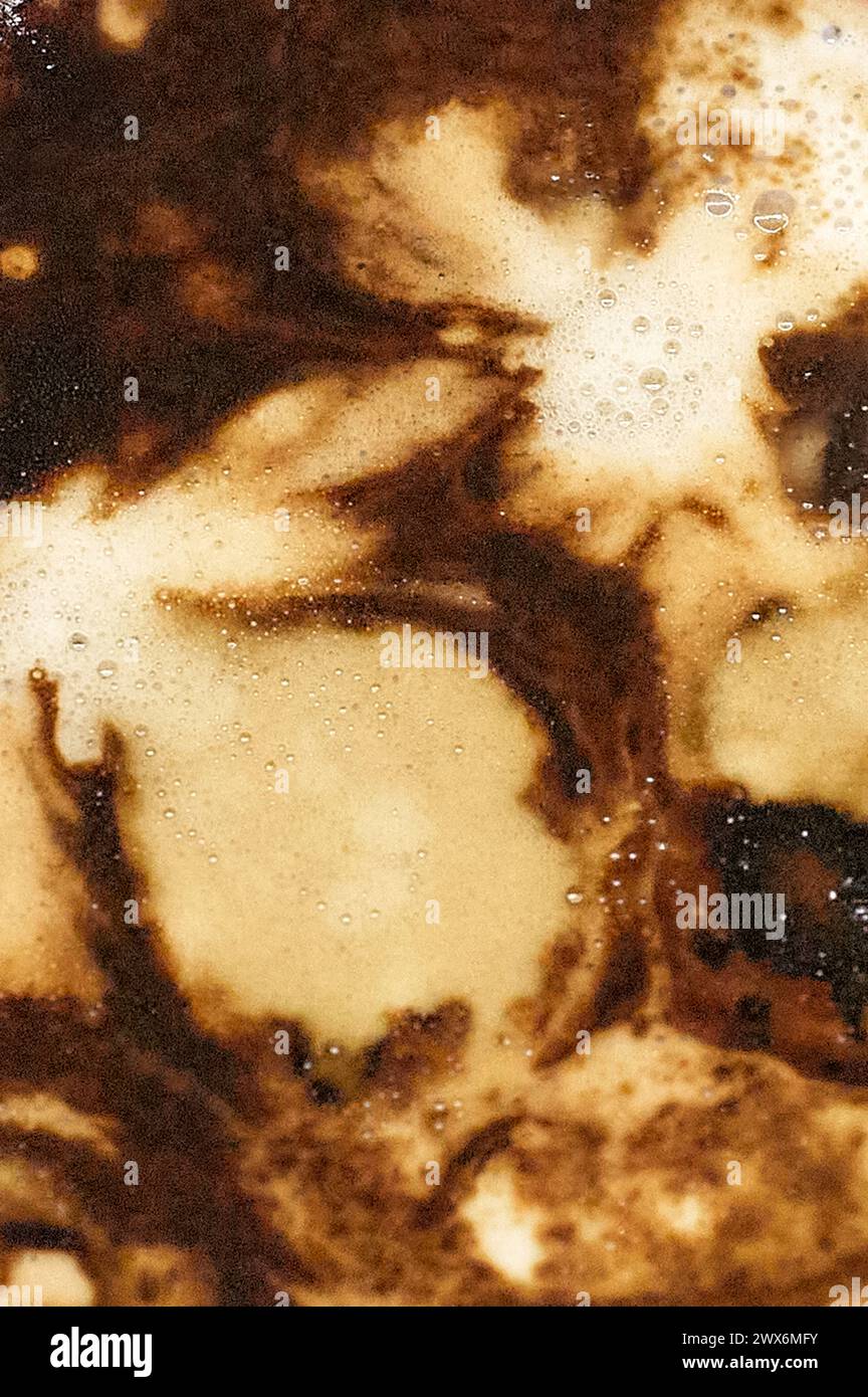 Close-up of a coffee with an abstract and artistic design in its foam, showing contrasts of color and texture that invite contemplation and enjoyment. Stock Photo