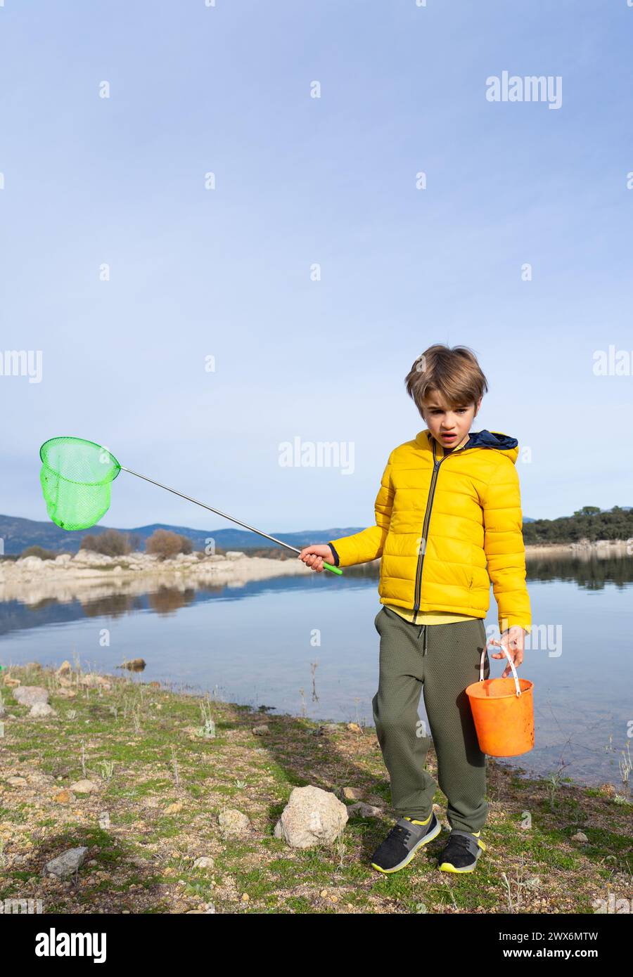 Boy with a fishing net in a lake Stock Photo