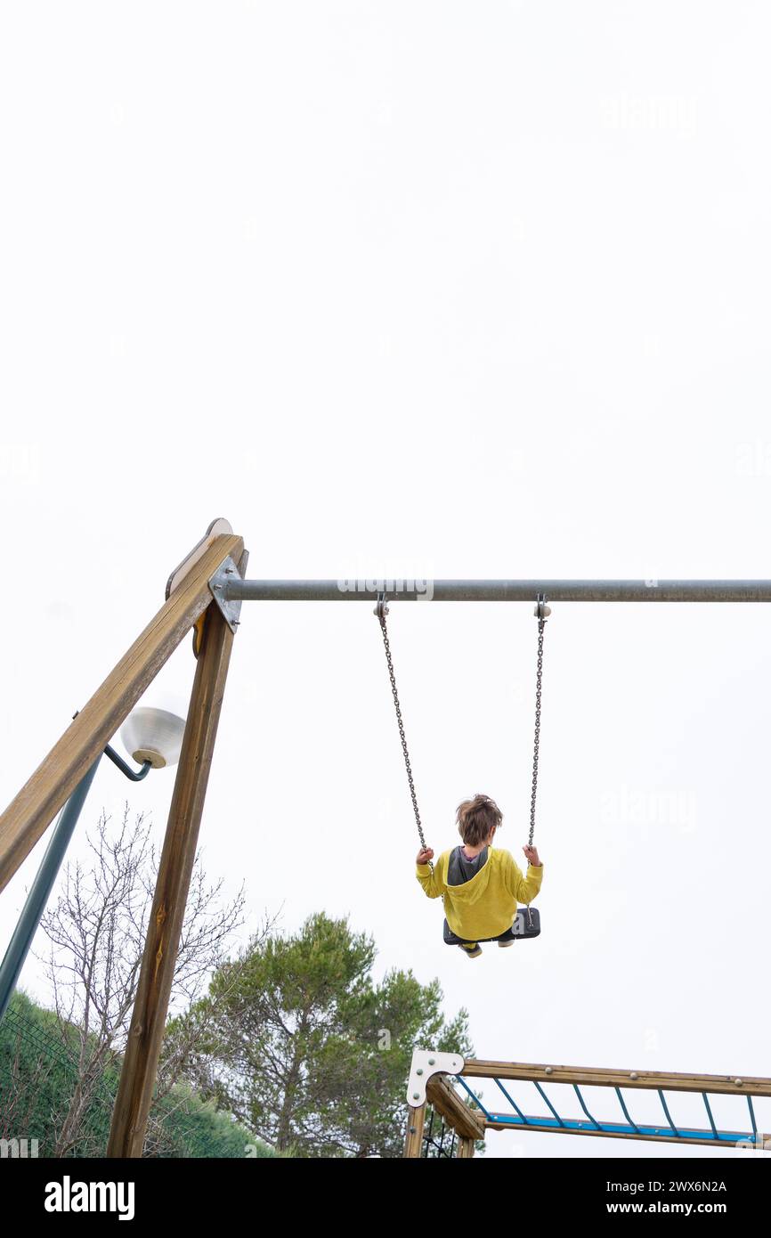 Boy swinging on a very high swing Stock Photo - Alamy