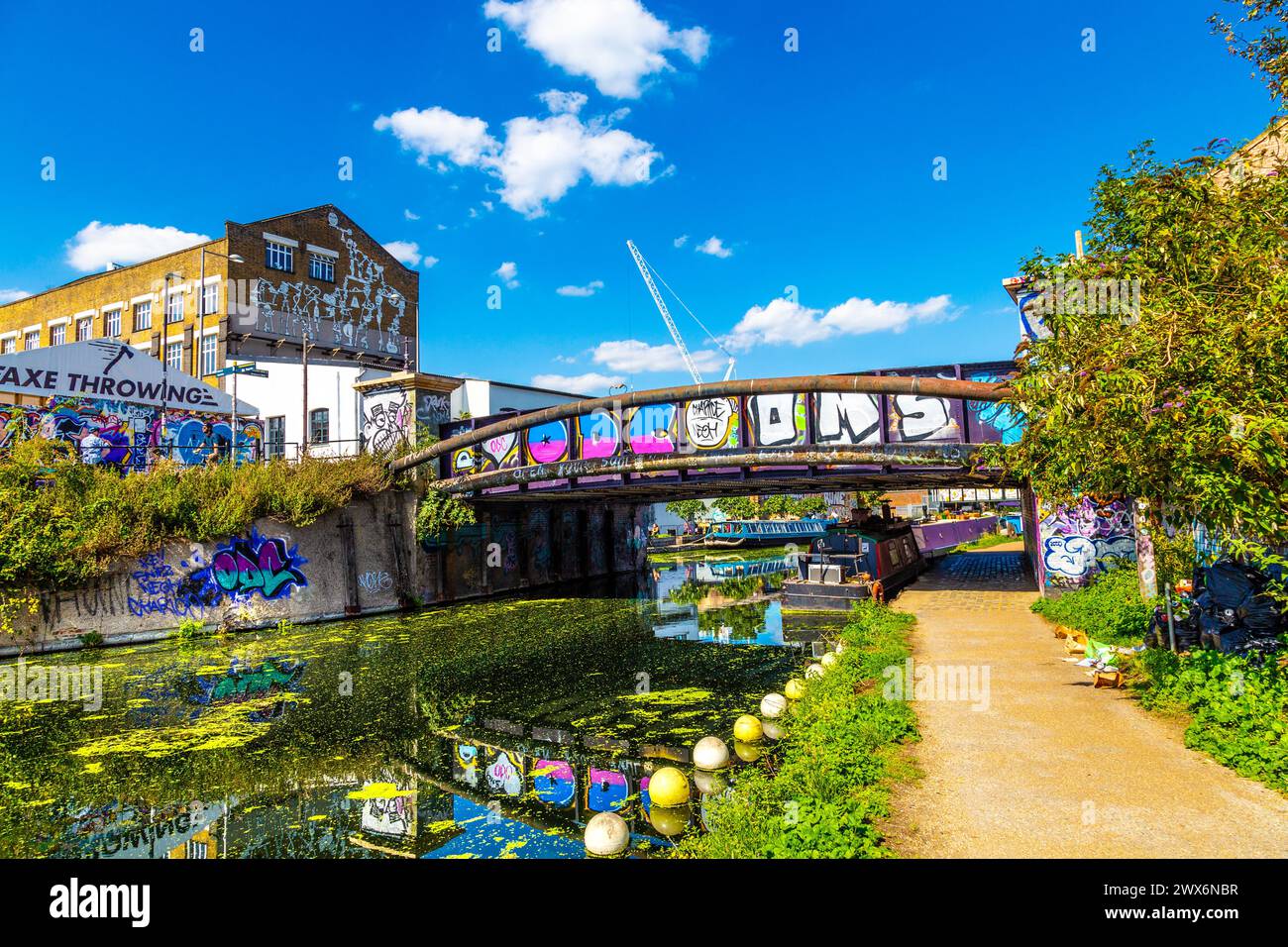Bridge over the River Lee Navigation Canal and Hackney Wick warehouses covered with street art, London, England Stock Photo