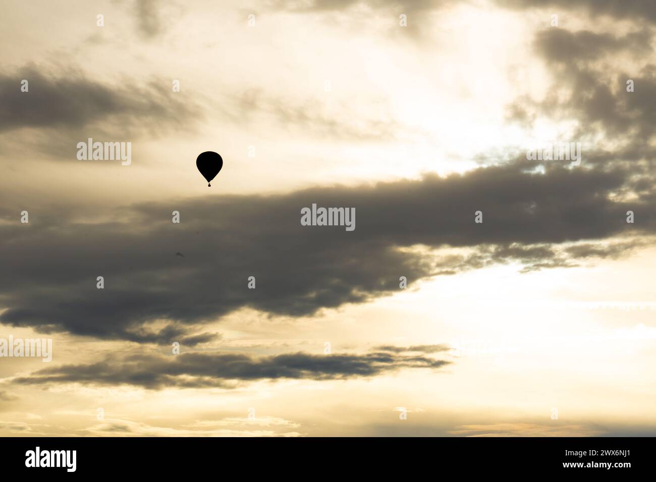 Hot air balloon flying in a cloudy sky Stock Photo