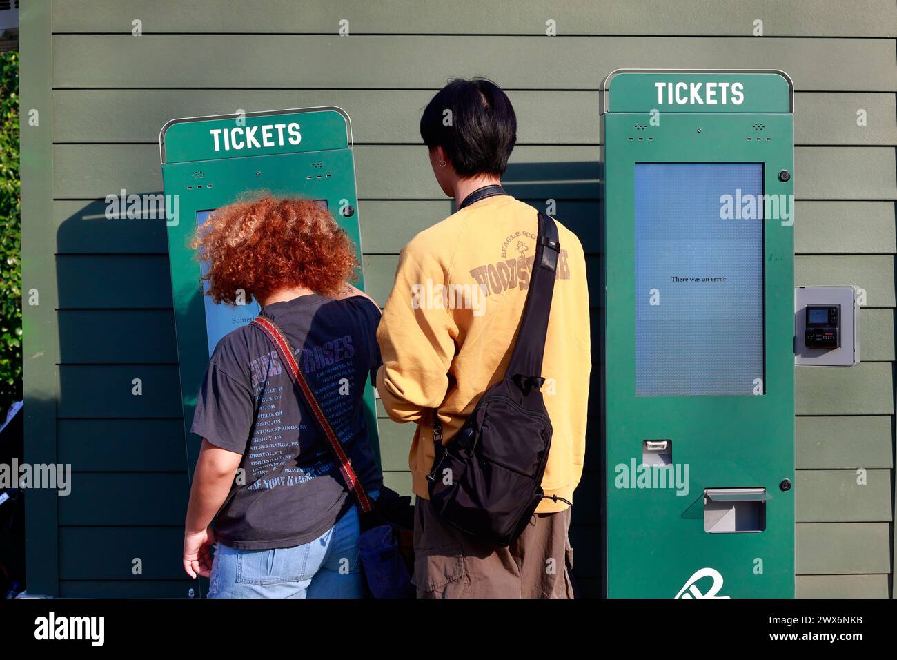 People using a credit card only automated ticket machine with one machine displaying error. Stock Photo