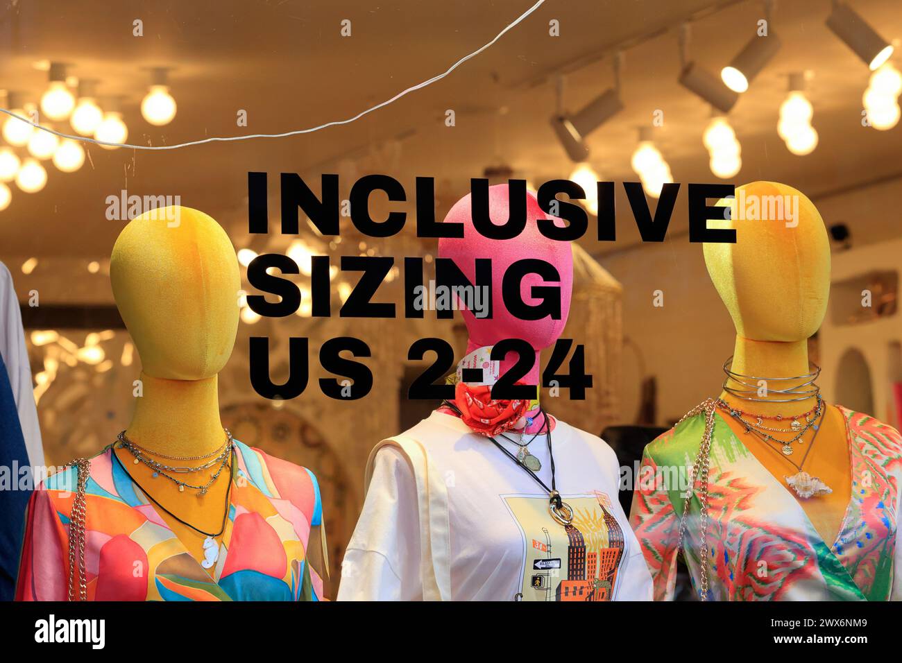 Window display advertising 'Inclusive Sizing US 2-24' at Never Fully Dressed clothing boutique, 243 Elizabeth St, New York City. Stock Photo