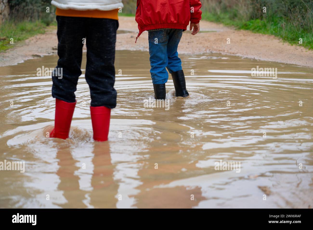 Children playing in a large puddle Stock Photo - Alamy