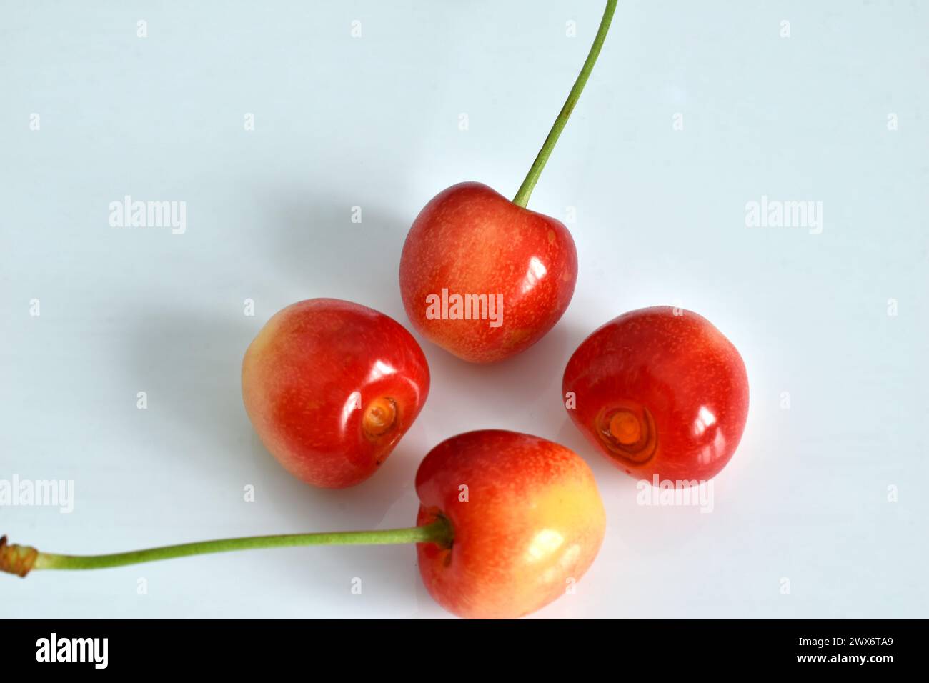 Ripe pink cherries lie on the table Stock Photo