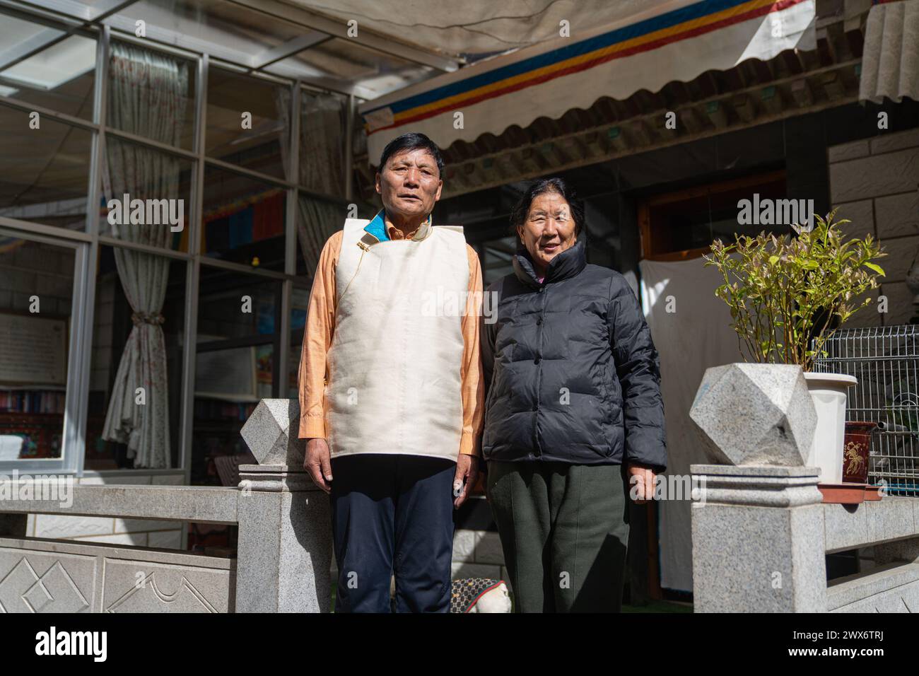 (240328) -- LHASA, March 28, 2024 (Xinhua) -- Phutsering poses for a photo with his wife Nyima Tsangmo at home in Lhasa, southwest China's Xizang Autonomous Region, March 23, 2024. Born in 1944 in Bainang County of Xigaze City, Phutsering was raised in a former serf family. A humble shack, situated near the manor where his mother toiled as a serf, served as his childhood home. Meanwhile, his father, employed at a separate manor, struggled to make ends meet by farming and crafting during lean months, barely generating sufficient income to cover the rent and taxes for their dwelling and fields. Stock Photo
