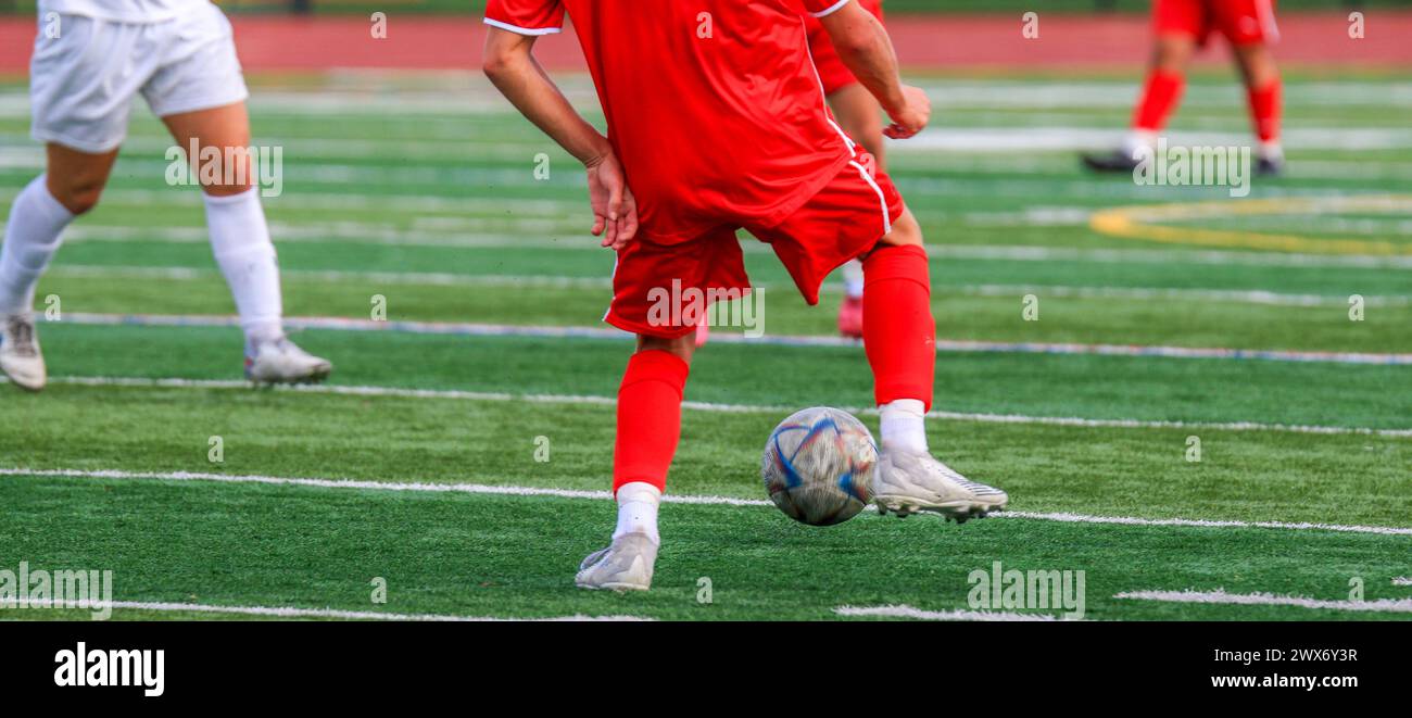 Rear view of boys playing soccer during a high school game. Stock Photo
