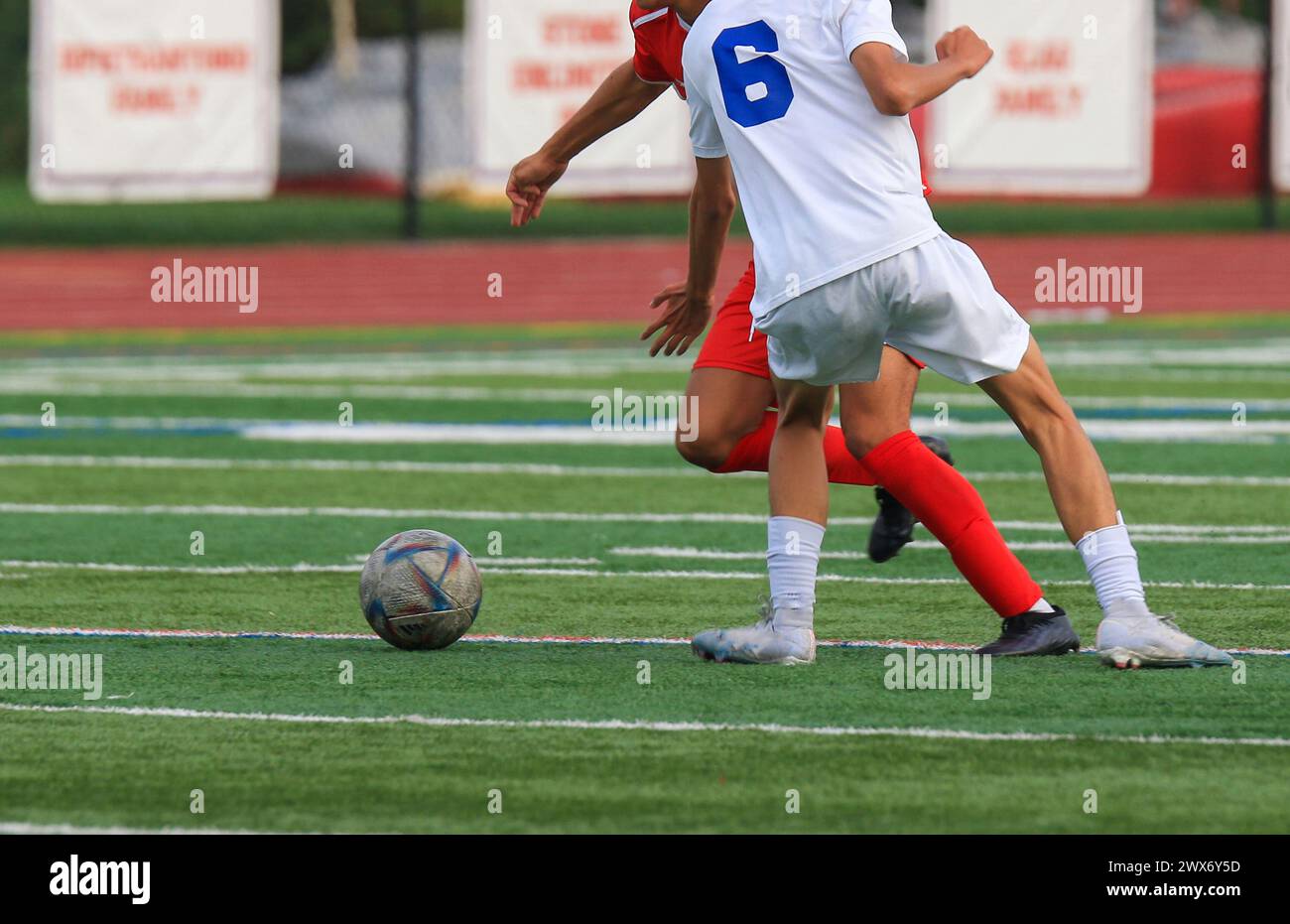 Two high school boys going for the soccer ball during a game. Stock Photo