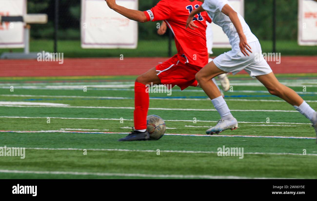 Close up of two high school boys playing soccer during a game fighting for posession of the soccer ball. Stock Photo