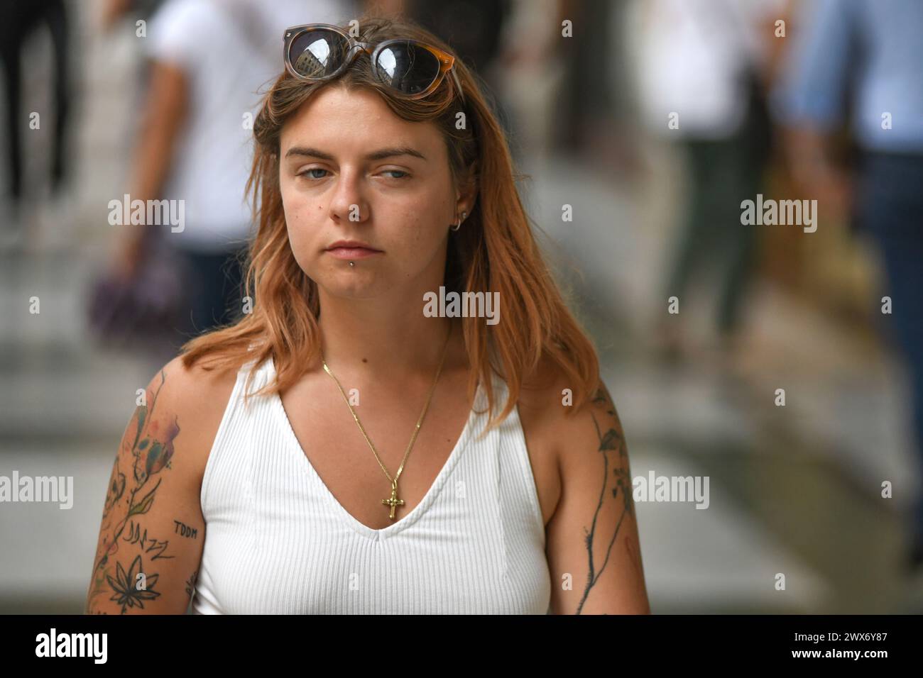 Italian girl with tattooed arm walking in Via Ugo Bassi, Bologna, Italy. Stock Photo