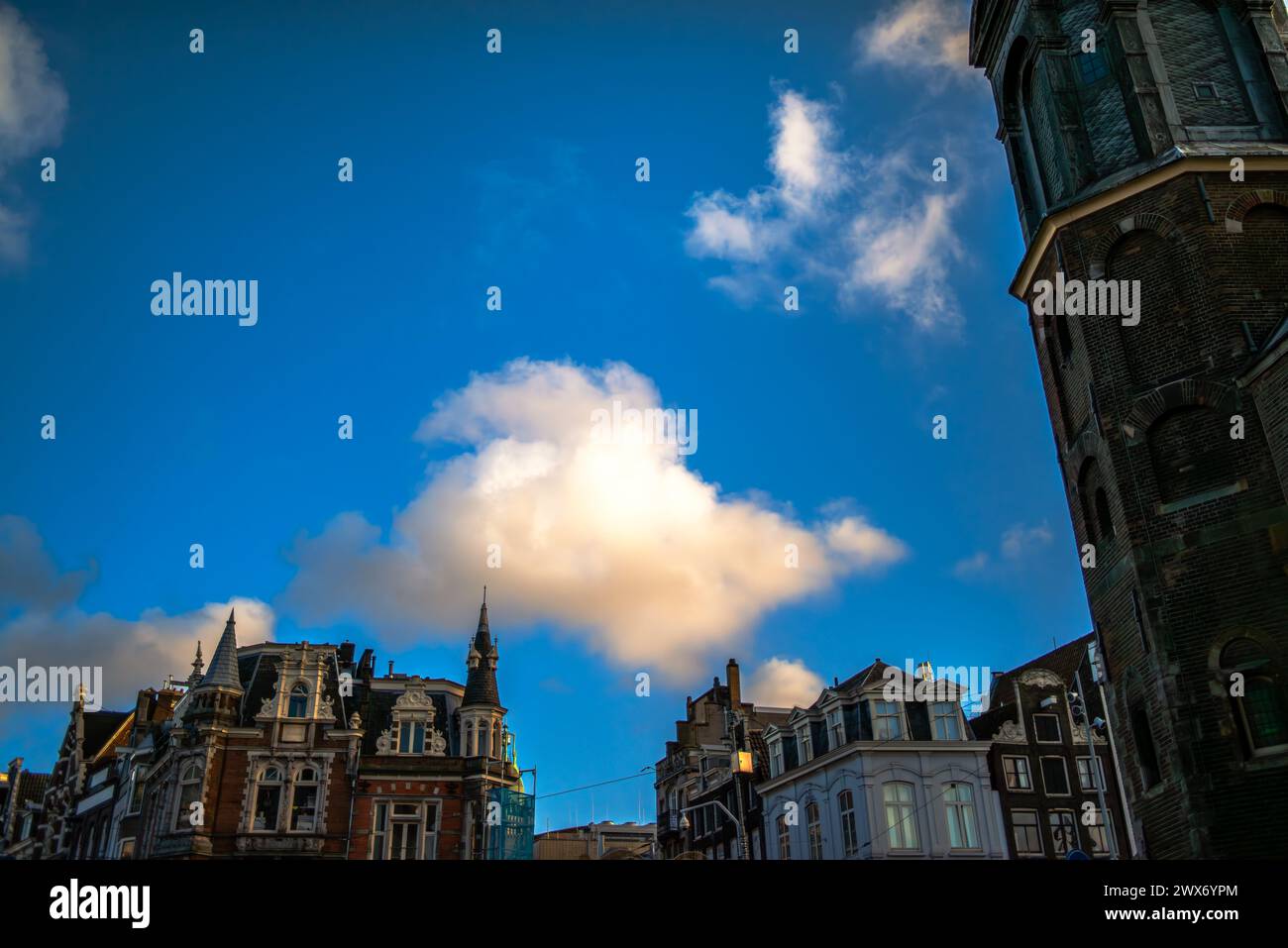 Explore the charm and architectural heritage of Amsterdam through its vibrant streets, where iconic buildings paint a picturesque cityscape. Stock Photo