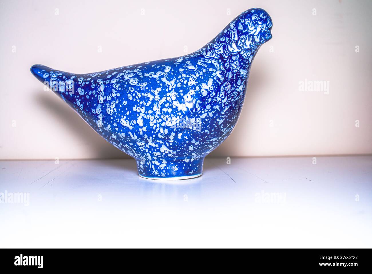 An elegant ceramic blue bird figure, meticulously crafted, adds an artistic touch to your decor with its delicate and ornamental presence. Stock Photo